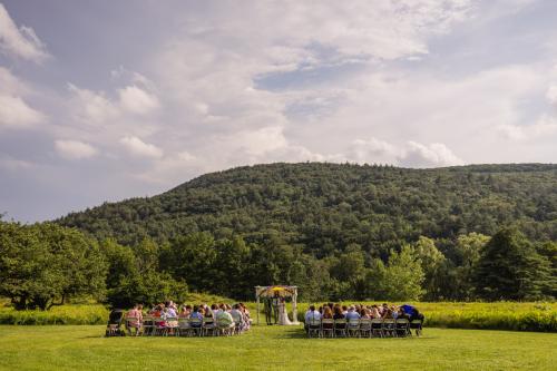 A group of people sitting in chairs in a field captured beautifully by your trusted Western MA Wedding Photographer.