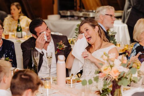 A Western MA Wedding Photographer capturing a joyful bride and groom laughing at their wedding reception.