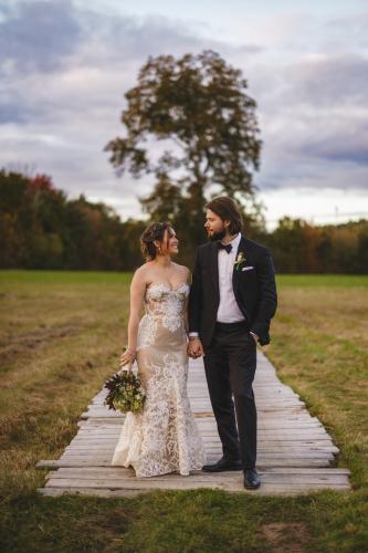 The Best of 2023 in Wedding Photography captures a stunning moment of a bride and groom on a wooden walkway in a field.