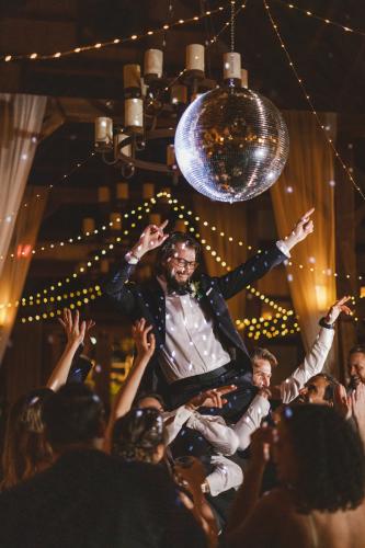 A man holding a disco ball at a wedding reception, capturing the best of 2023 in wedding photography.