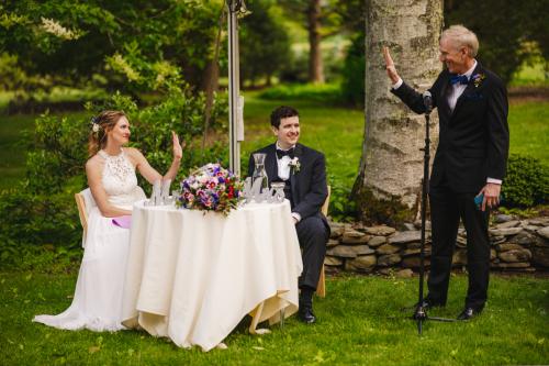 A Western MA Wedding Photographer captures the heartfelt moment of a bride and groom giving a toast at their wedding.