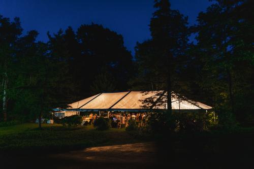 A tent lit up at night in a wooded area, perfect for wedding photography.