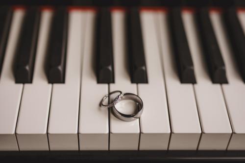 A wedding ring elegantly placed on a piano keyboard by a Western MA Wedding Photographer.