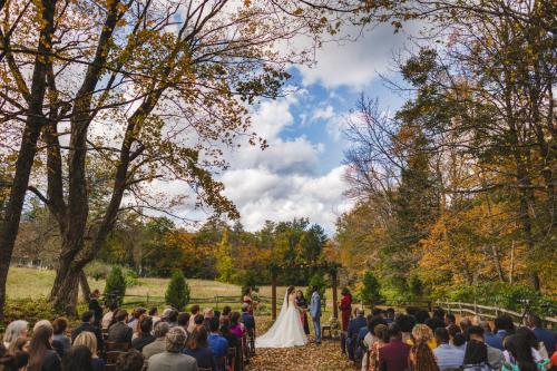 A Western MA wedding ceremony in a wooded area with trees in the background captured by a skilled wedding photographer.