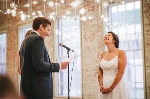A Western MA Wedding Photographer captures the joy of a bride and groom laughing during their wedding ceremony.