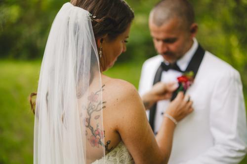 A bride and groom with tattoos gracefully putting on their wedding ties, captured by a talented Western MA Wedding Photographer.