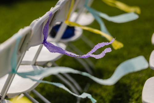 A row of chairs adorned with vibrant ribbons captured by a Western MA Wedding Photographer.