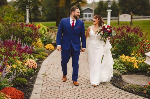 Capturing beautiful moments of a bride and groom strolling along a picturesque garden path in their wedding photography.