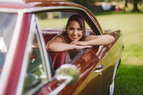 A bride leaning out of the window of a classic car captured by a Western MA Wedding Photographer.