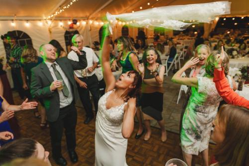 Capturing a joyful bride tossing confetti at a vibrant wedding reception, showcasing the art of wedding photography.