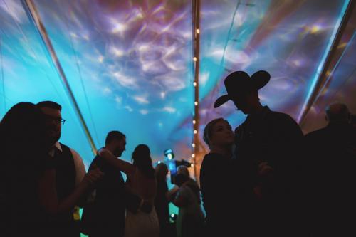 A group of people standing under a colorful tent captured by a Western MA Wedding Photographer.