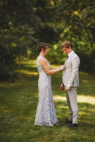 A Western MA Wedding Photographer captures a serene moment of a bride and groom standing together in the woods.