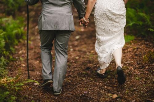 The newlyweds embark on their journey together, hand in hand, through a scenic forest path. This mesmerizing wedding photography capture showcases the magic of their love, as they create memories that
