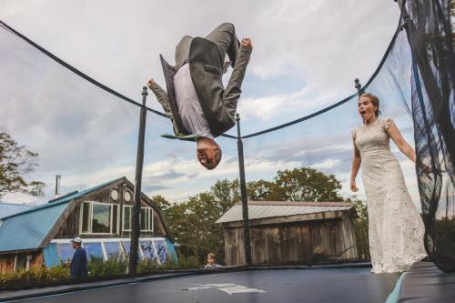 The best 2023 wedding photography captures a remarkable moment of a bride and groom as they joyfully flip on a trampoline.