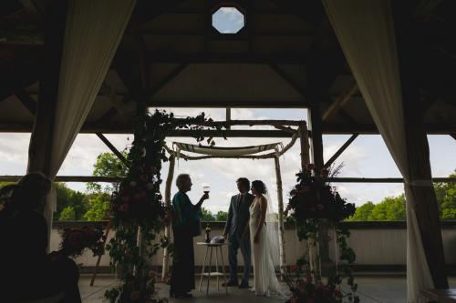 A Western MA Wedding Photographer captures the special moment as a bride and groom exchange vows in a barn.