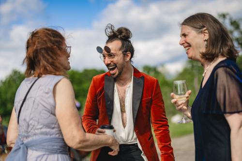 A group of people engaged in lively conversation at an outdoor event, captured beautifully by a Western MA Wedding Photographer.