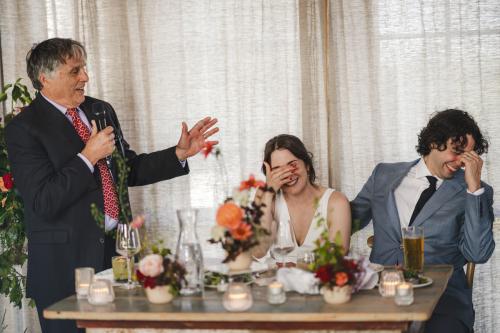 A Western MA wedding photographer captures the special moment of a man speaking into a microphone at a wedding reception.