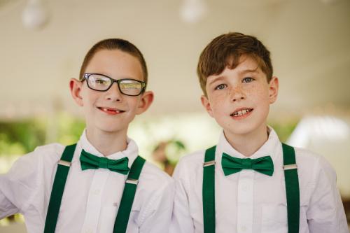 Western MA Wedding Photographer capturing two boys wearing green suspenders and bow ties.