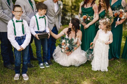 A woman in a white dress holding flowers surrounded by a group of people, captured beautifully in this best of 2023 wedding photography shot.