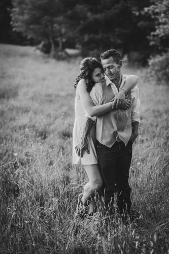 Black and white photo of a couple hugging in a field captured by a Western MA Wedding Photographer.