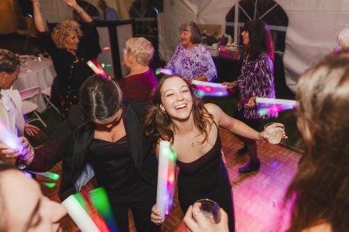 A group of people dancing at a party with lightsabers captured by a Western MA Wedding Photographer.