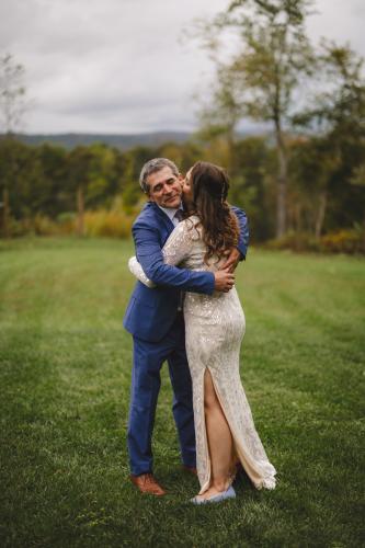 A bride and groom hugging in a field captured by a talented Western MA Wedding Photographer.